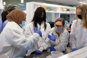 Lab workers teaching the SPIN Girls Fellows how to work at a scientific bench (2)