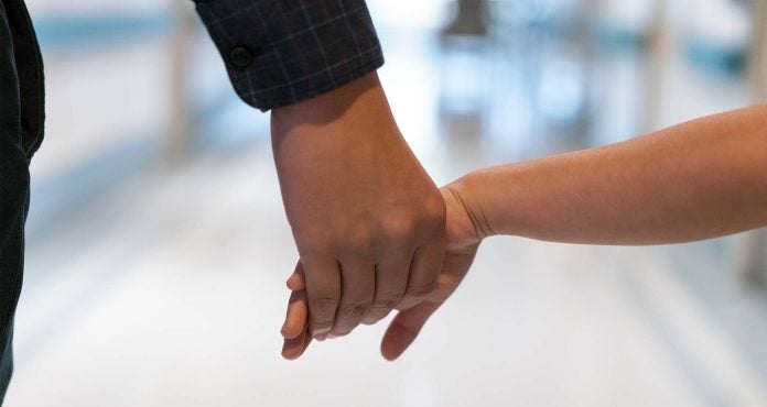 Child holds adults hand